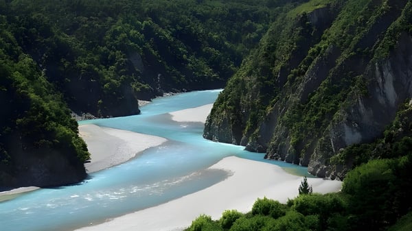 Un río de color turquesa serpentea a través de un cañón boscoso con rocas cubiertas de musgo cerca de Christchurch Boys High School.