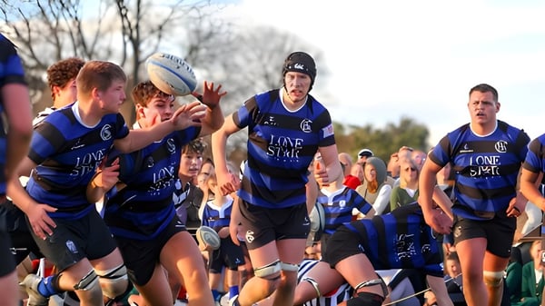 Un grupo de jugadores de rugby en camiseta azul durante el juego en el campo de Christchurch Boys High School.