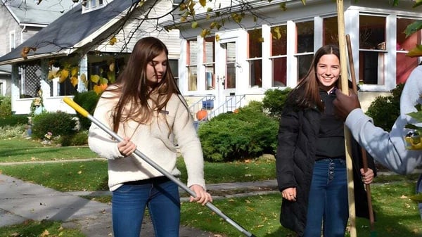 Dos estudiantes caminan juntas por la acera frente a un edificio en el campus de la Christian Central Academy en otoño.