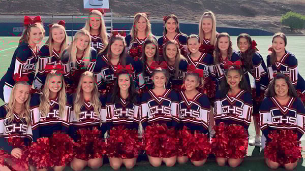 Un grupo de animadoras posa con uniformes uniformes y pompones en el campo deportivo de las Christian Unified Schools.