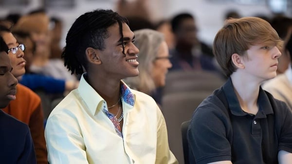 Un grupo de estudiantes está reunido en el campus de la Church Farm School.