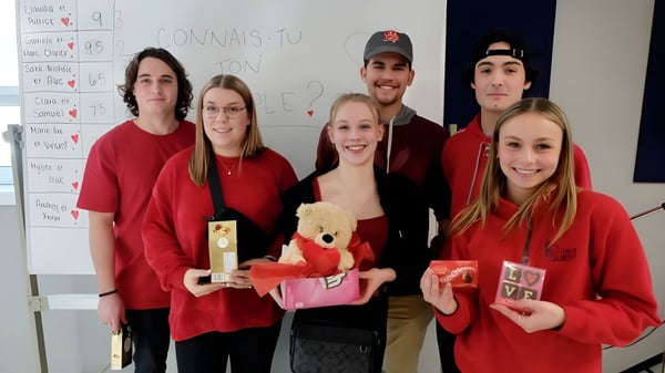 Un grupo de estudiantes de la Cité des Jeunes A.-M.-Sormany está frente a un pizarrón sosteniendo varios objetos.