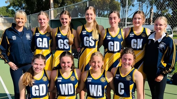 Un grupo de jugadoras de netball de Clare High School posan juntas en la cancha de netball.