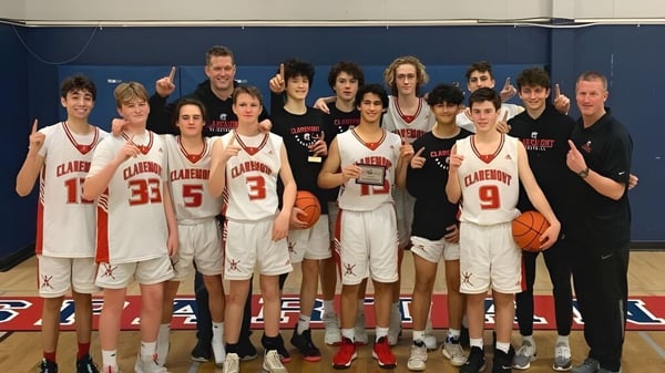 Estudiantes de la Claremont Secondary School posan juntos en el gimnasio como equipo de baloncesto.