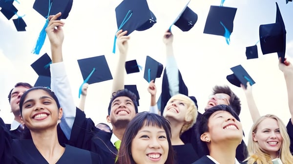 Un grupo de graduados del Clarin College lanzan sus birretes al cielo despejado.