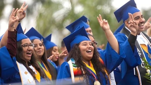 Los graduados de la Clarke Road Secondary School celebran su ceremonia de graduación al aire libre.
