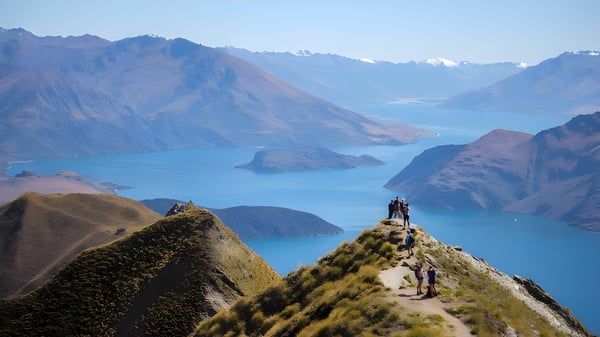 Un grupo de excursionistas disfruta de la vista de montañas y un lago en el paisaje del Classic Plus Programm.