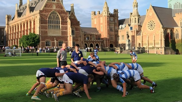 Un grupo de estudiantes en ropa deportiva está en el césped del Clifton College en un círculo de equipo.