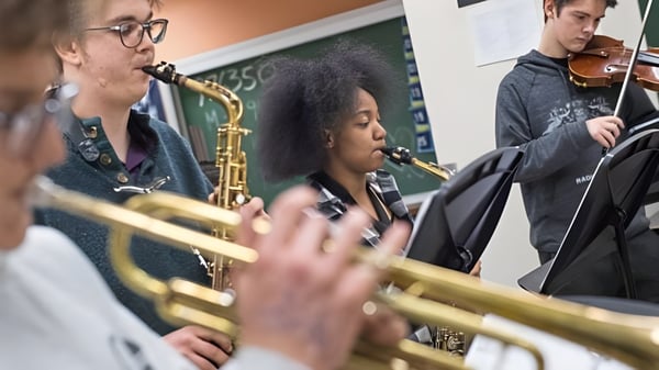 Estudiantes del Clovis Unified School District tocan en la clase de música varios instrumentos como saxofón y violín en un aula.