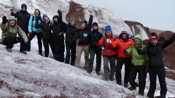Los estudiantes de la Coláiste an Chreagáin están juntos en un paisaje montañoso invernal cubierto de nieve.
