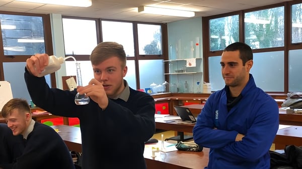 Dos hombres están de pie en una oficina o aula en el campus de la Coláiste Mhuire Mullingar.