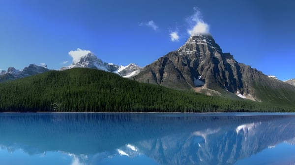 El panorama montañoso alpino se refleja en el lago frente al Collège Notre-Dame.