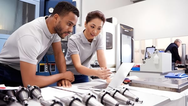 Dos personas trabajan juntas en una computadora en el espacio de trabajo del College of the Canyons.