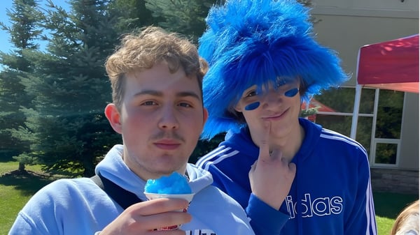 Dos estudiantes del Collège Sacré-Coeur están afuera frente a un fondo boscoso.