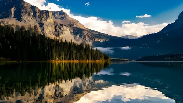 Un tranquilo lago alpino con montañas nevadas se refleja en las aguas tranquilas cerca del Collège Sacré-Coeur.