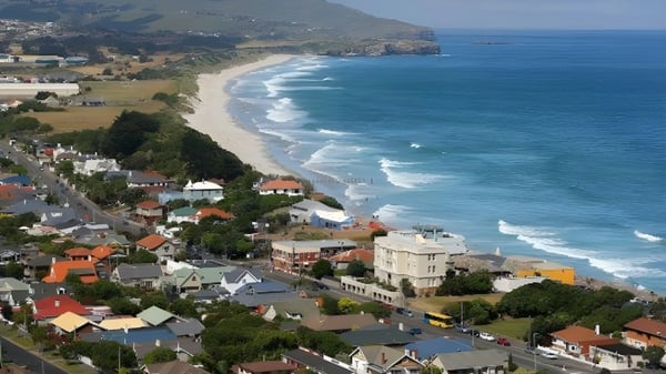 Vista de la costa con playa de arena y montañas cerca del Columba College.