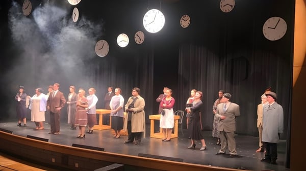Estudiantes de la Comstock Park High School presentan una obra de teatro en trajes históricos con niebla escénica y grandes relojes.