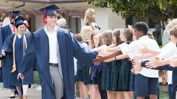 Los graduados de la Covenant Day School son felicitados en el área exterior festiva por familiares y amigos.