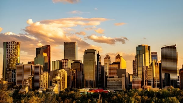 Vista de la línea del horizonte al atardecer con áreas verdes en primer plano cerca de la Crescent Heights High School.