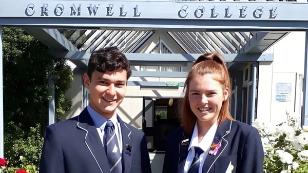 Dos estudiantes están frente al edificio del Cromwell College.