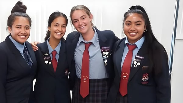 Cuatro estudiantes en uniformes escolares posan juntas en un entorno de aula en el campus del Cullinane College.