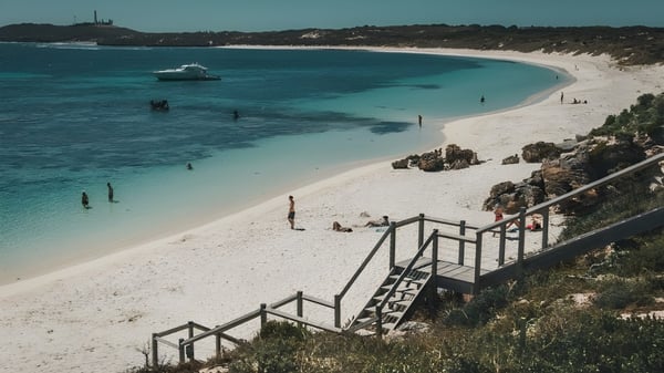 Una playa con agua turquesa clara y un pequeño bote frente al campus del Cyril Jackson Senior Campus.