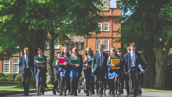 Un grupo de alumnos está frente a un edificio histórico de ladrillo en el campus de Dauntsey’s School.