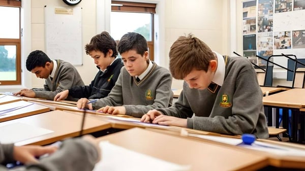 Estudiantes en uniformes escolares trabajan concentrados en el aula del De la Salle College Churchtown.