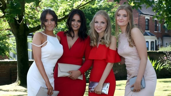 Cuatro jóvenes mujeres están juntas en el área verde del campus del Denstone College y posan para una foto grupal.