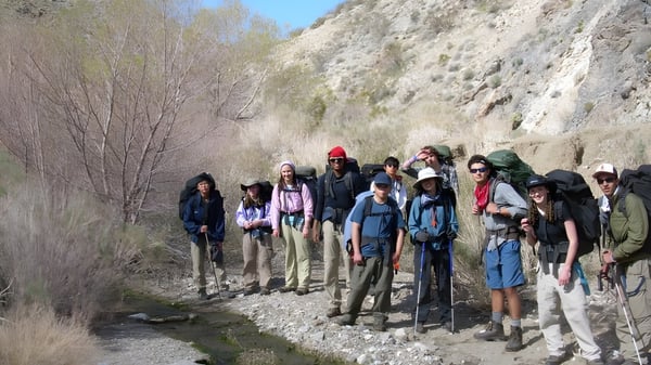 Un grupo de alumnas y alumnos del Dominican College Wicklow camina por un sendero rocoso a través de un paisaje áspero.