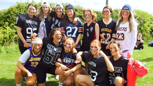 Un grupo de jóvenes alumnas del Dominican College Wicklow está al aire libre en un campo juntas.