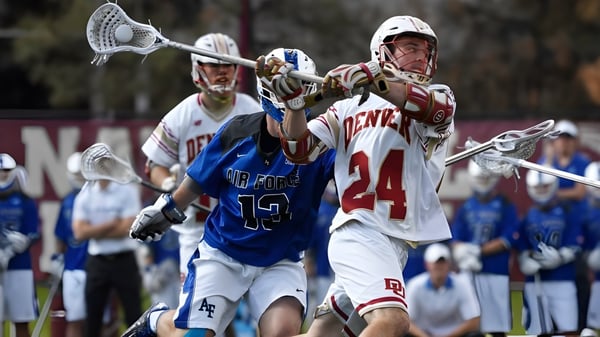 Dos jugadores de lacrosse del Don College luchan en el campo por el balón.