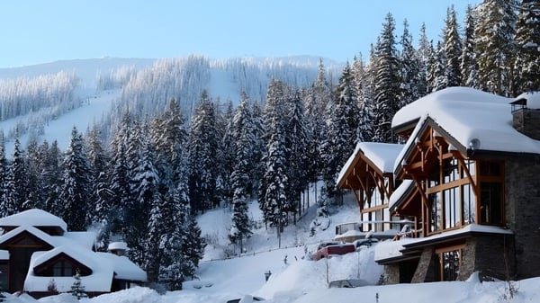 Un paisaje montañoso nevado con una cabaña de madera entre pinos en el terreno de la Donald A. Wilson School.