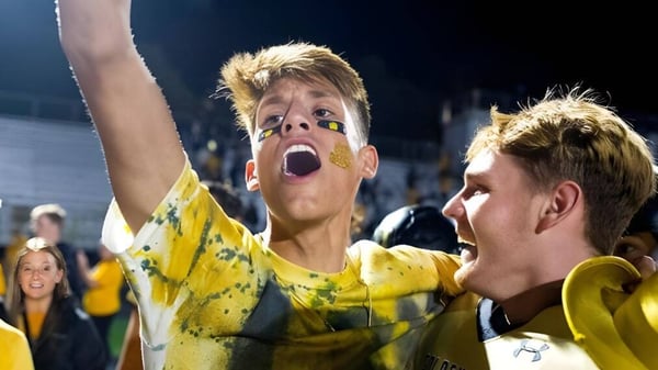 Dos estudiantes de la Douglas Community School celebran en un evento en el estadio y muestran su entusiasmo.