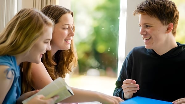 Tres estudiantes de D'Overbroeck's College conversan animadamente en el área exterior de la escuela.