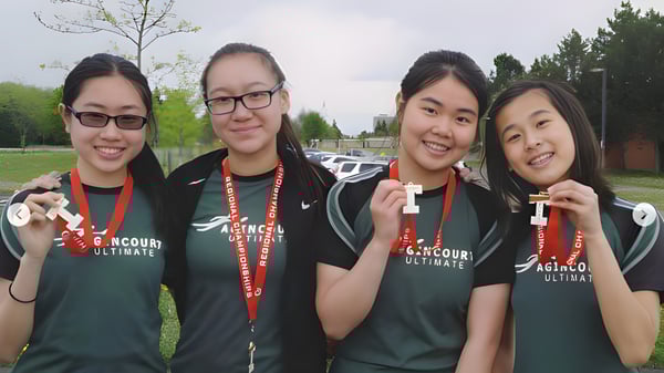Cuatro estudiantes del Dr. Norman Bethune Collegiate Institute llevan camisetas verdes y están juntos en un campo de juego.