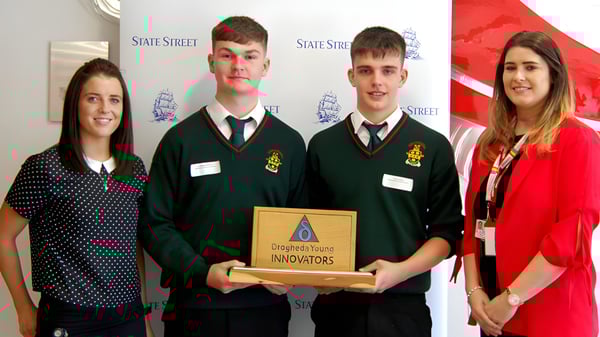 Cuatro estudiantes de la Drogheda Grammar School sostienen juntos el trofeo Designated Innovators en la escuela.