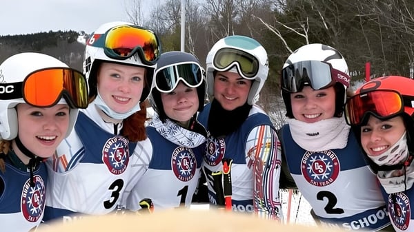 Un grupo de estudiantes de la Dublin School posan con equipo de esquí juntos en un paisaje nevado.