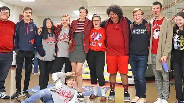 Un grupo de estudiantes está reunido en el área común de D.W. Poppy Secondary School.
