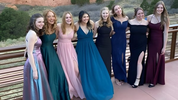 Un grupo de estudiantes de la Earl Marriott Secondary School está en una plataforma de madera frente a un paisaje natural.