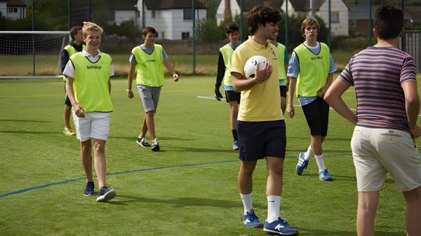 Un grupo de estudiantes de la Earlscliffe School se reúne en un campo deportivo para una actividad.