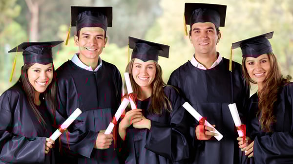 Un grupo de graduadas y graduados del Earnshaw State College en togas y birretes negros se agrupan frente a un fondo natural.