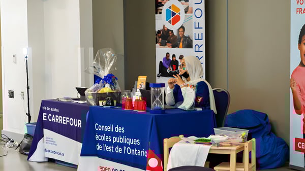 Un stand de información de las Eastern Ontario Public Schools con un letrero en un pasillo con carteles en las paredes.