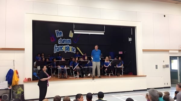 Un grupo de músicos y un director realizan un concierto en el escenario de la École des Deux-Rives.