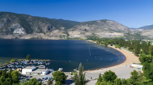 Vista de un lago con playa de arena y puerto de botes en el paisaje cerca de la École Entre-Lacs.