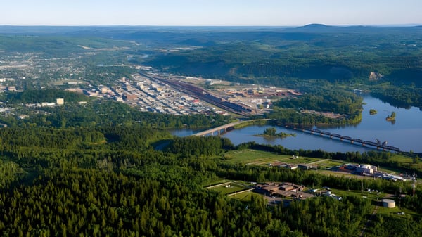Vista de un paisaje boscoso con un río y un pequeño pueblo en el valle cerca de la École Franco-Nord.