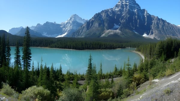 Un tranquilo lago turquesa se encuentra en medio de montañas nevadas y un bosque perenne en el terreno de la École secondaire Népisiguit.