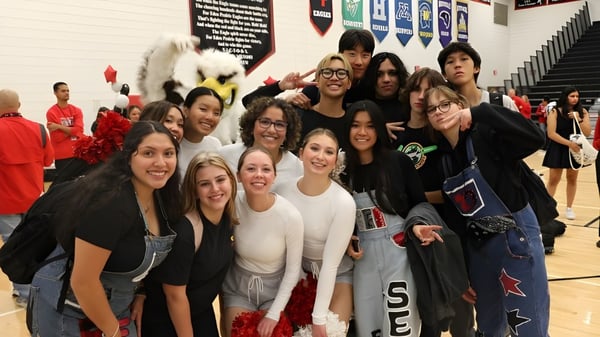 Un grupo de estudiantes de Eden Prairie Schools posan en el área deportiva de la escuela para una foto grupal.