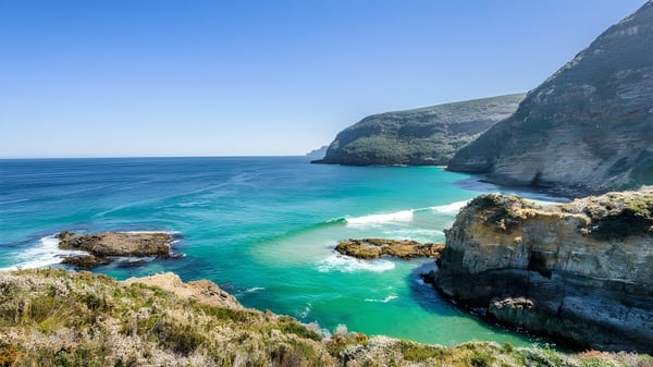 Paisaje costero con acantilados rocosos y agua turquesa cerca del Elizabeth College.