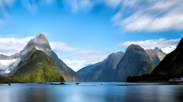 Un lago tranquilo con pequeños botes frente a montañas nevadas cerca de la Epsom Girls Grammar School.